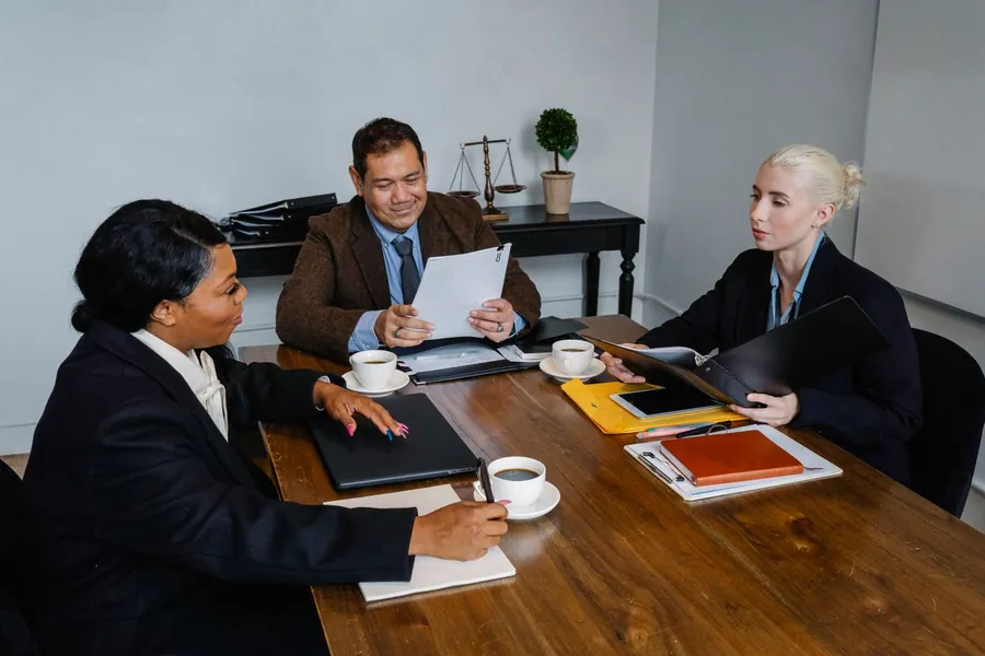 Reunión de trabajo en una oficina con documentación sobre la mesa