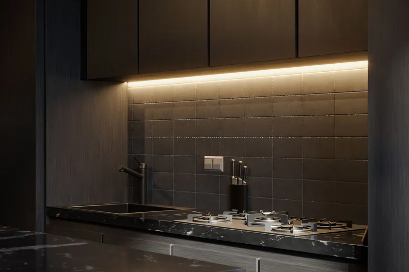 Detalle de una cocina moderna con muebles oscuros y encimera de gas