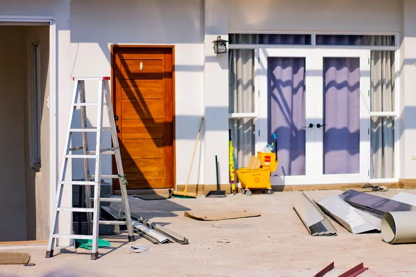 Fachada de vivienda en obras con andamios y materiales de construcción